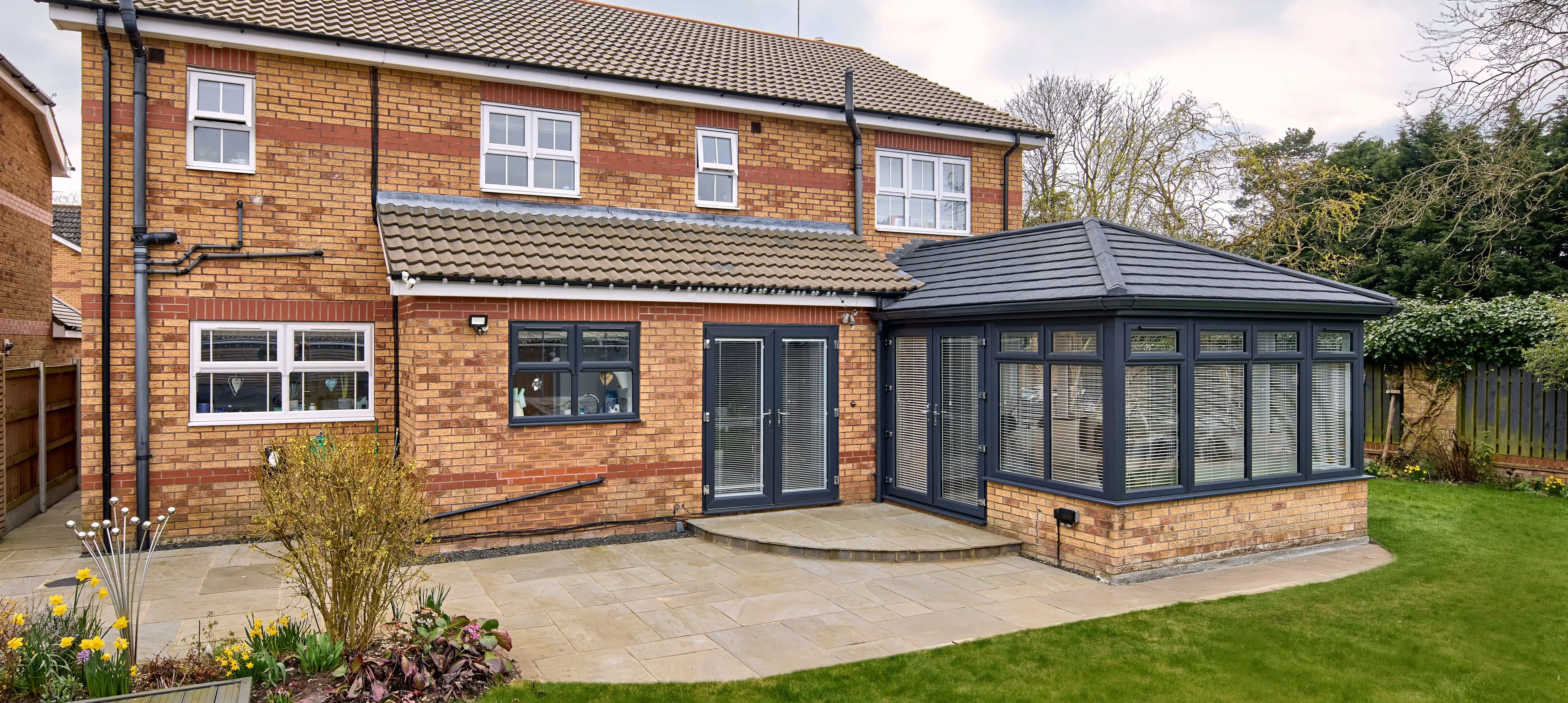 Single-storey extension with anthracite frames and solid roof